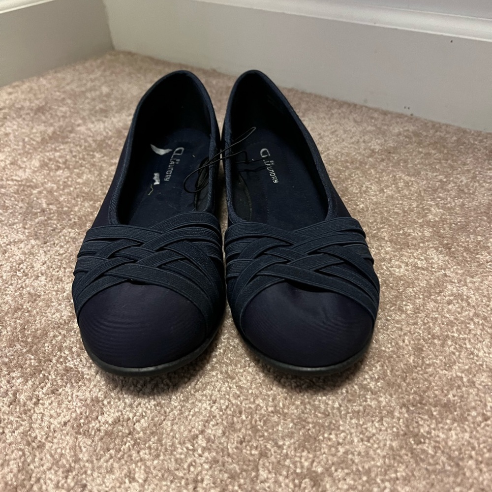 Navy flats with strap details.
